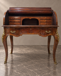 Marquetry cylinder bureau with the writing interior open in a styled setting