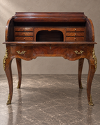 Marquetry cylinder bureau with the writing interior open in a styled setting