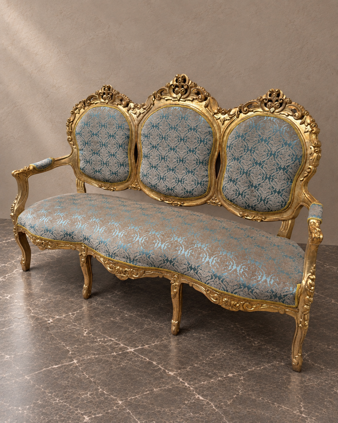 Blue damask sofa with carved gilt-tone frame in a styled setting