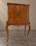 Walnut drinks cabinet with closed doors and cabriole legs in a styled setting