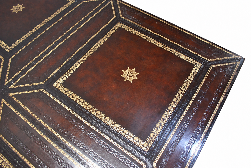 Carved Mahogany Coffee Table with Gilt-Tooled Leather Top — detail on white background