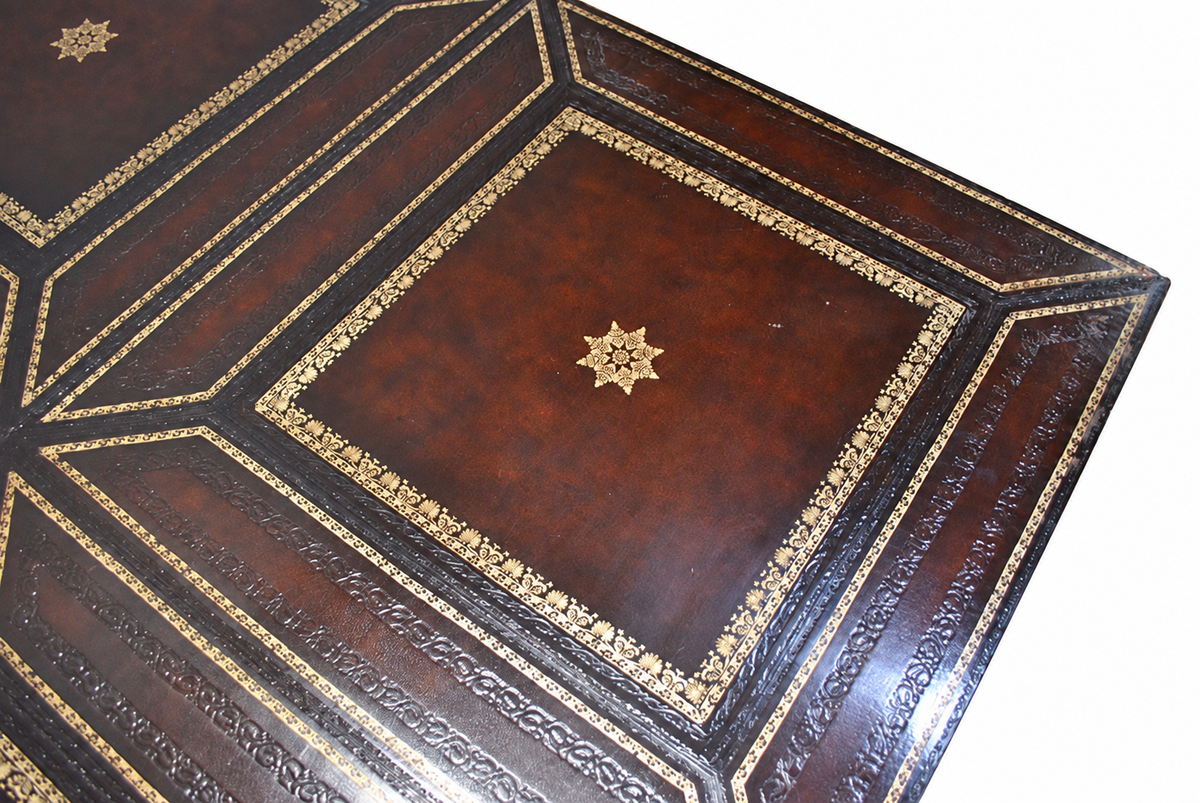 Carved Mahogany Coffee Table with Gilt-Tooled Leather Top — detail on white background