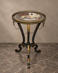 Napoleon III-style round ebonised table with painted porcelain top, gilt mounts and chain swags — main view