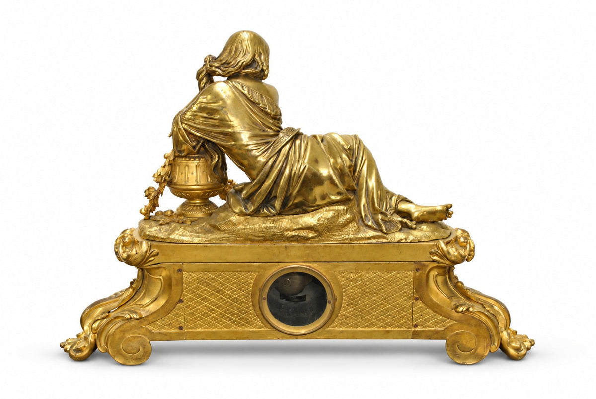 Rear view of the gilt-bronze clock showing mechanism access and original patina on white