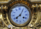 Original close-up of the clock dial with blue Roman numerals and aged gilt-bronze surround