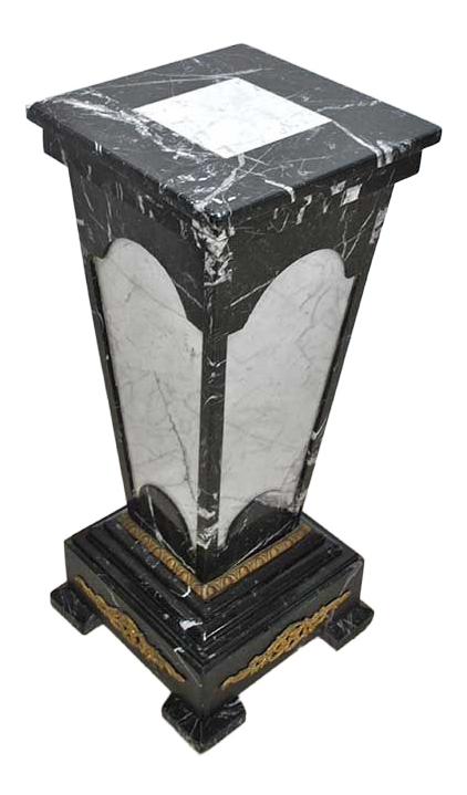 Original oblique view of the complete marble pedestal on white, showing its square top, contrasting stone panels, mounts and stepped base