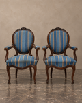 Pair of Isabelino walnut armchairs with blue and ochre-striped upholstery — main frontal view