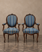 Pair of Isabelino walnut armchairs with blue and ochre-striped upholstery — main frontal view