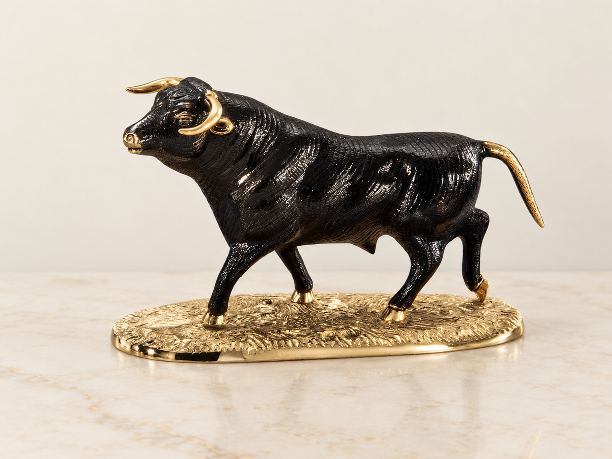 Dark bull sculpture on a gold-tone base