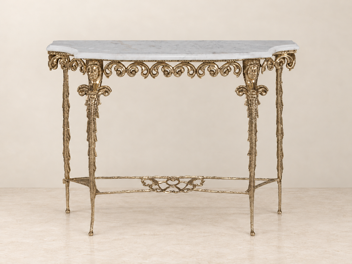 Ornate Console Table with Twin Mask Detail — ivory wall and cream marble setting.