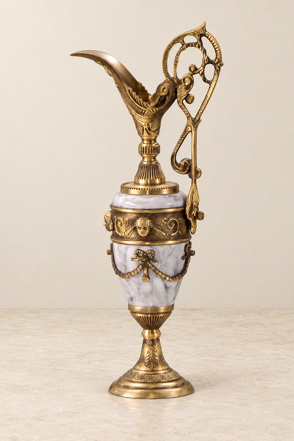 Grey Veined Decorative Ewer with Bows and Garlands — ivory wall and cream marble setting.